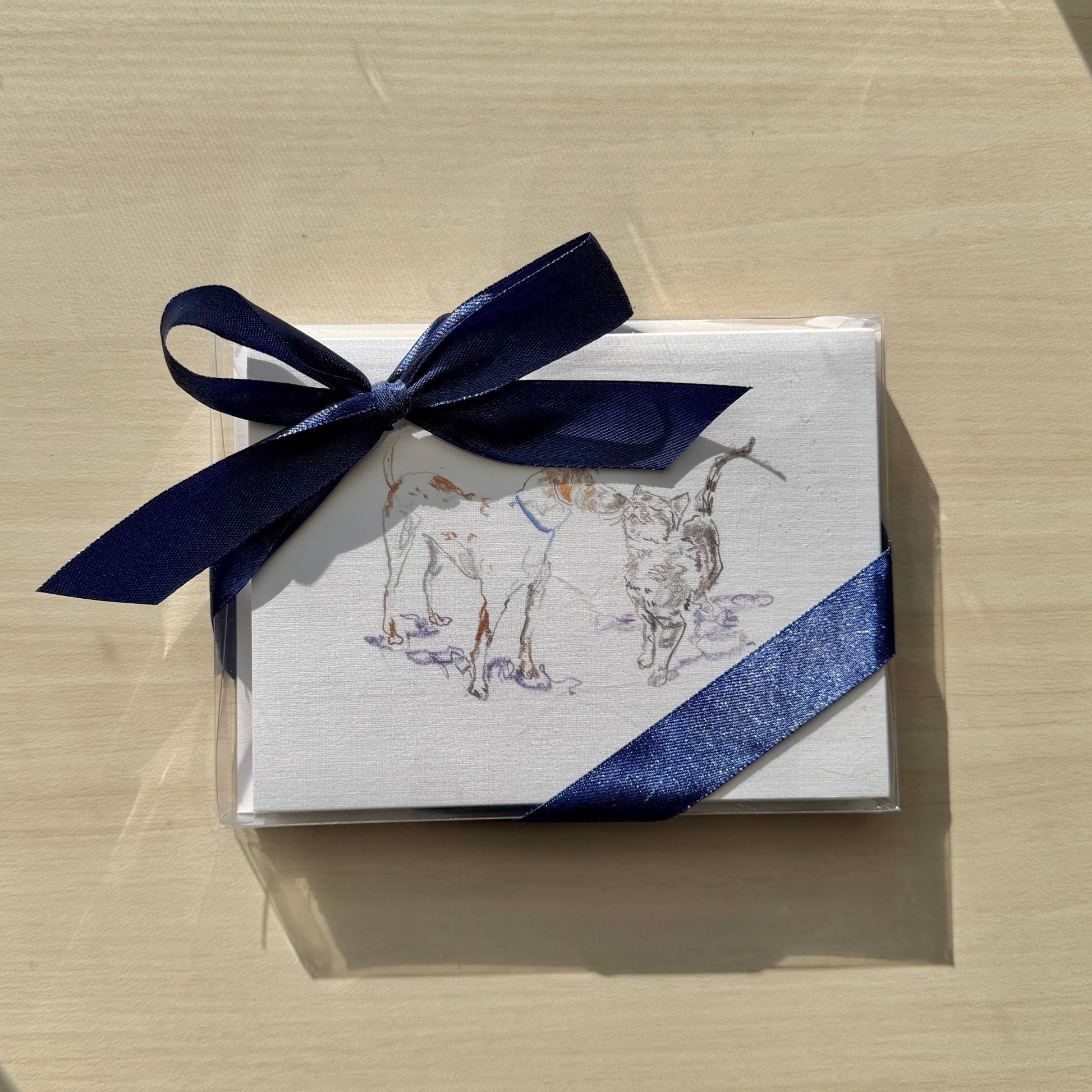 Small box with a blue ribbon on a light wooden surface